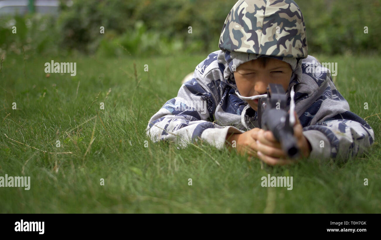 boy in camoflauge playing war shoots a toy gun Stock Photo - Alamy