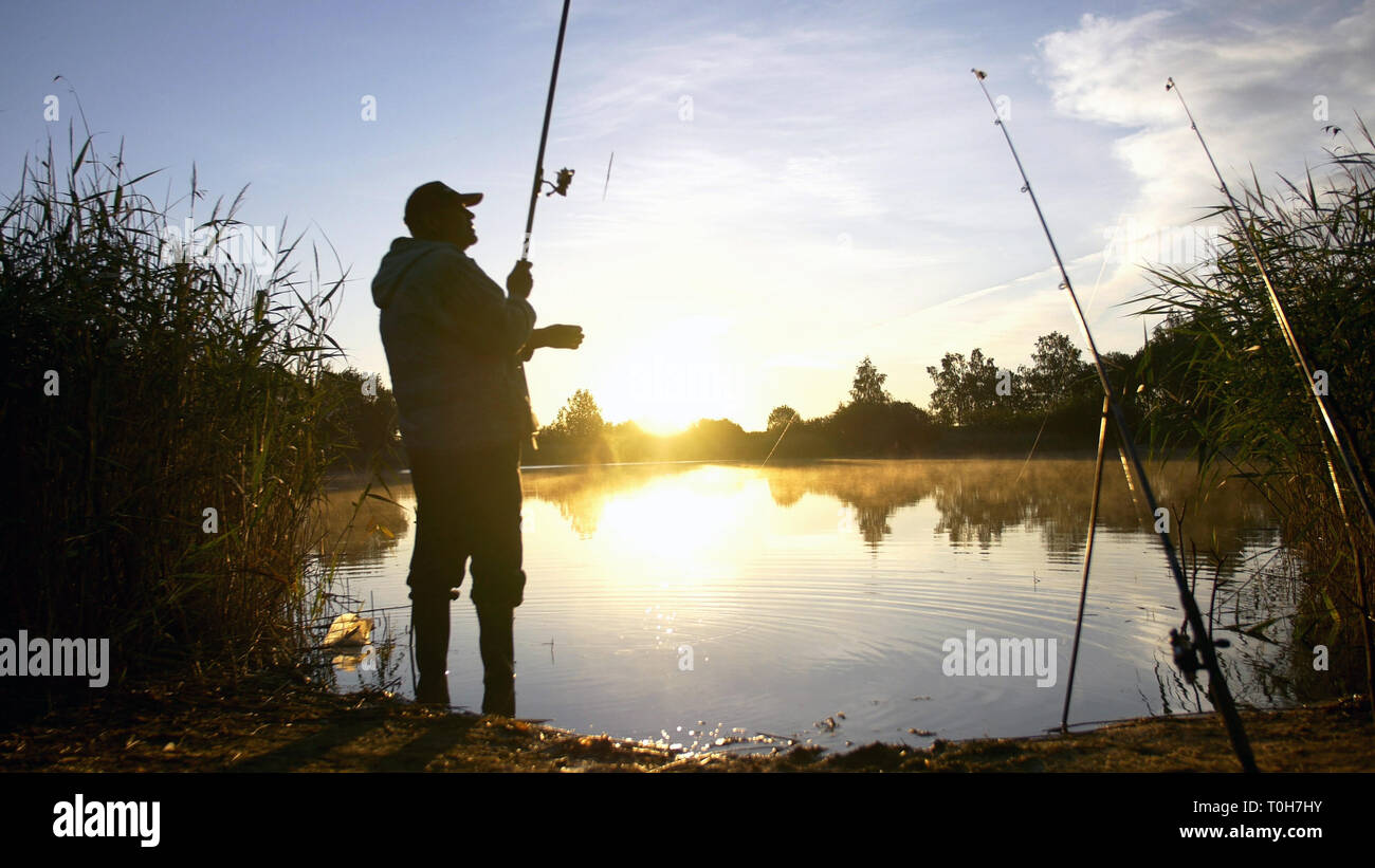 silhouette man fishing on the pond at sunset Stock Photo - Alamy