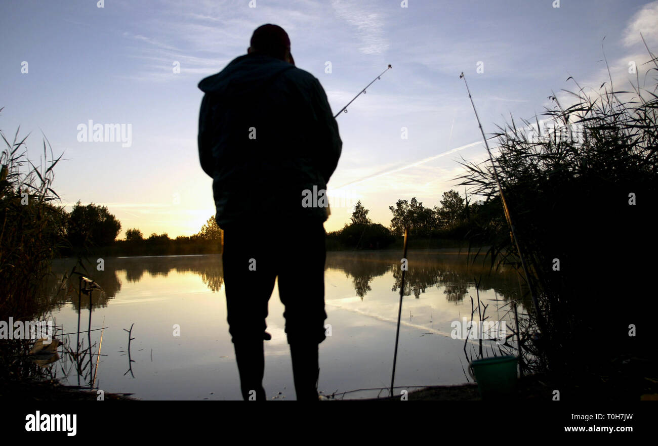 silhouette man fishing on the pond at sunset Stock Photo - Alamy