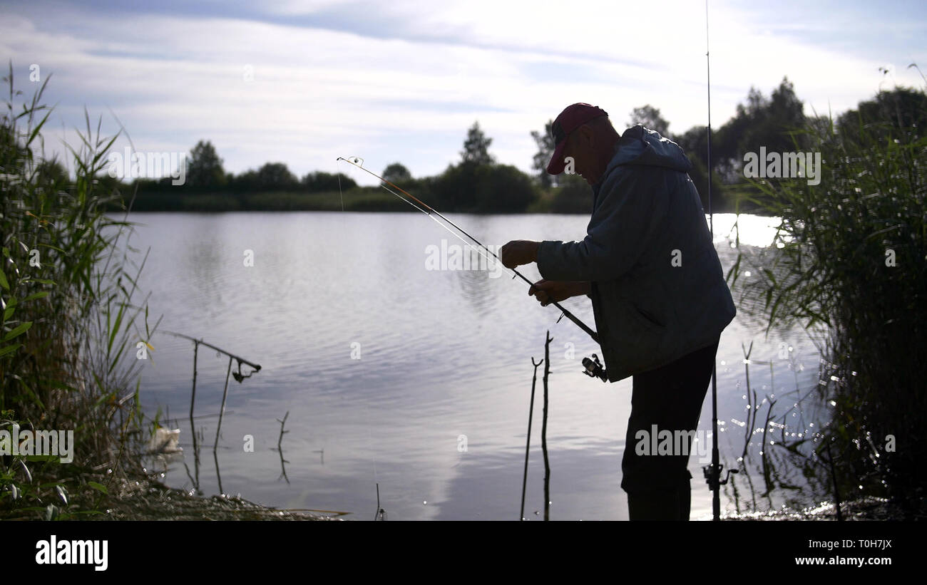silhouette man fishing on the pond at sunset Stock Photo - Alamy