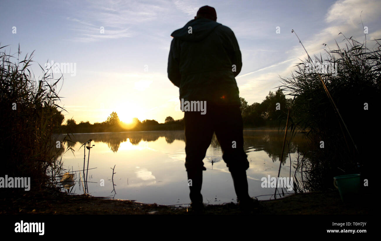 silhouette man fishing on the pond at sunset Stock Photo - Alamy