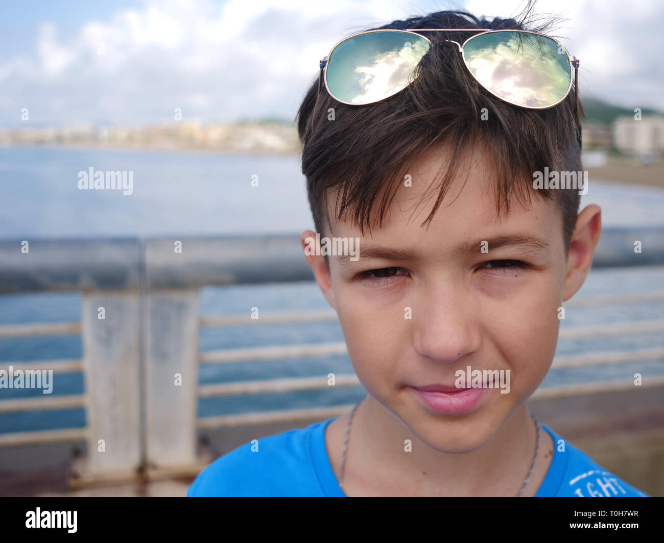 portrait of a funny boy with glasses on his head looks into the camera Stock Photo