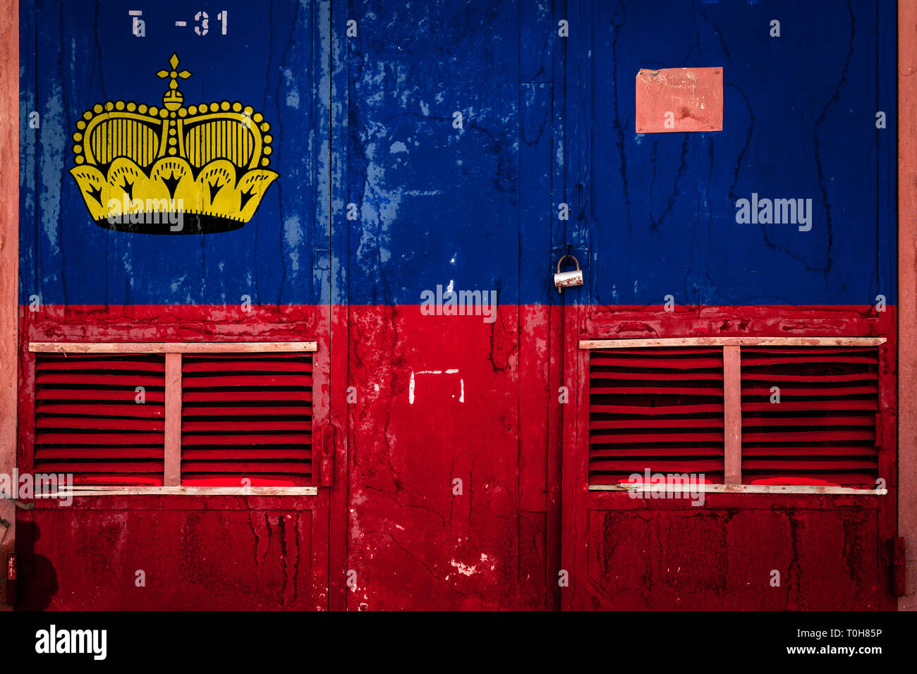 Closeup of old warehouse gate with national flag of Liechtenstein
