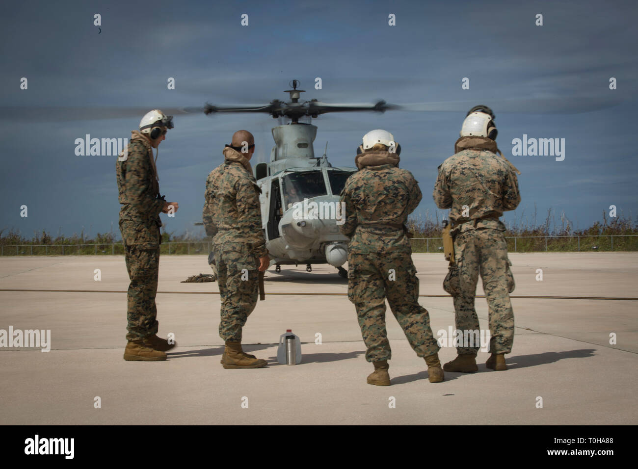 Marines with Combat Logistics Battalion 31 and Alpha Company, Battalion Landing Team, 1st Battalion, 4th Marines, prepare to board a UH-1Y Huey helicopter at Anderson Air Force Base, Guam, before a visit to Tinian, Commonwealth of the Northern Mariana Islands, March 11, 2019. Marines and Sailors with CLB-31 led a multi-service task force, partnering with the Federal Emergency Management Agency, to help the U.S. citizens of Tinian begin recovery efforts in the wake of Super Typhoon Yutu last year. The Marines and Sailors, currently participating in two weeks of unit-level training on nearby Gua Stock Photo