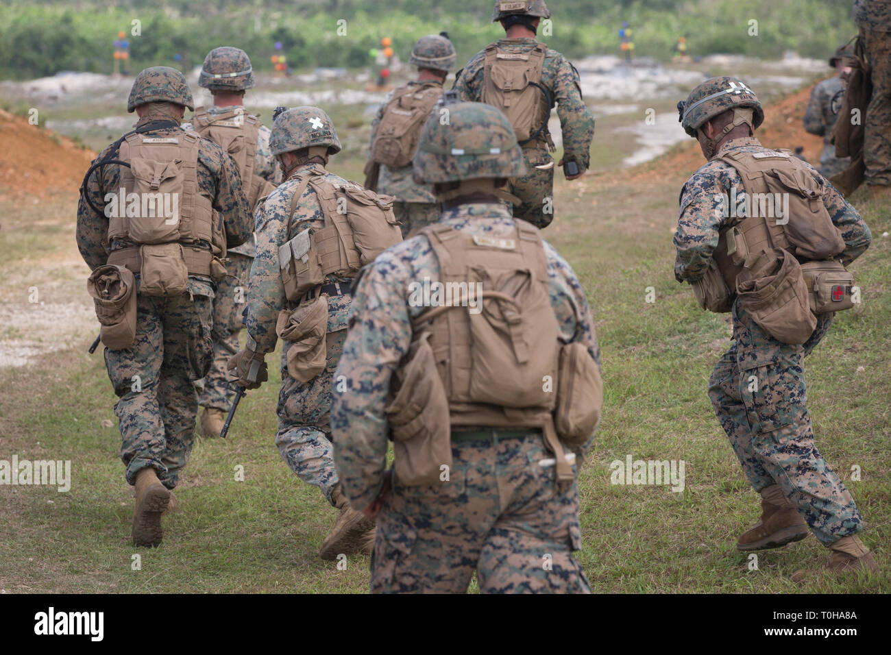 Marines with Alpha Company, Battlion Landing Team, 1st Battalion, 4th Marines, the “China Marines,” run toward the firing line during live-fire training at Anderson Air Force Base, Guam, March 12, 2019. Alpha Company Marines, the small boat raid specialists for BLT 1/4, the Ground Combat Element for the 31st Marine Expeditionary Unit, conducted two weeks of unit-level training on Guam. The 31st MEU, the Marine Corps’ only continuously forward-deployed MEU partnering with the U.S. Navy's Amphibious Squadron 11, provides a flexible and lethal force ready to perform a wide range of military opera Stock Photo