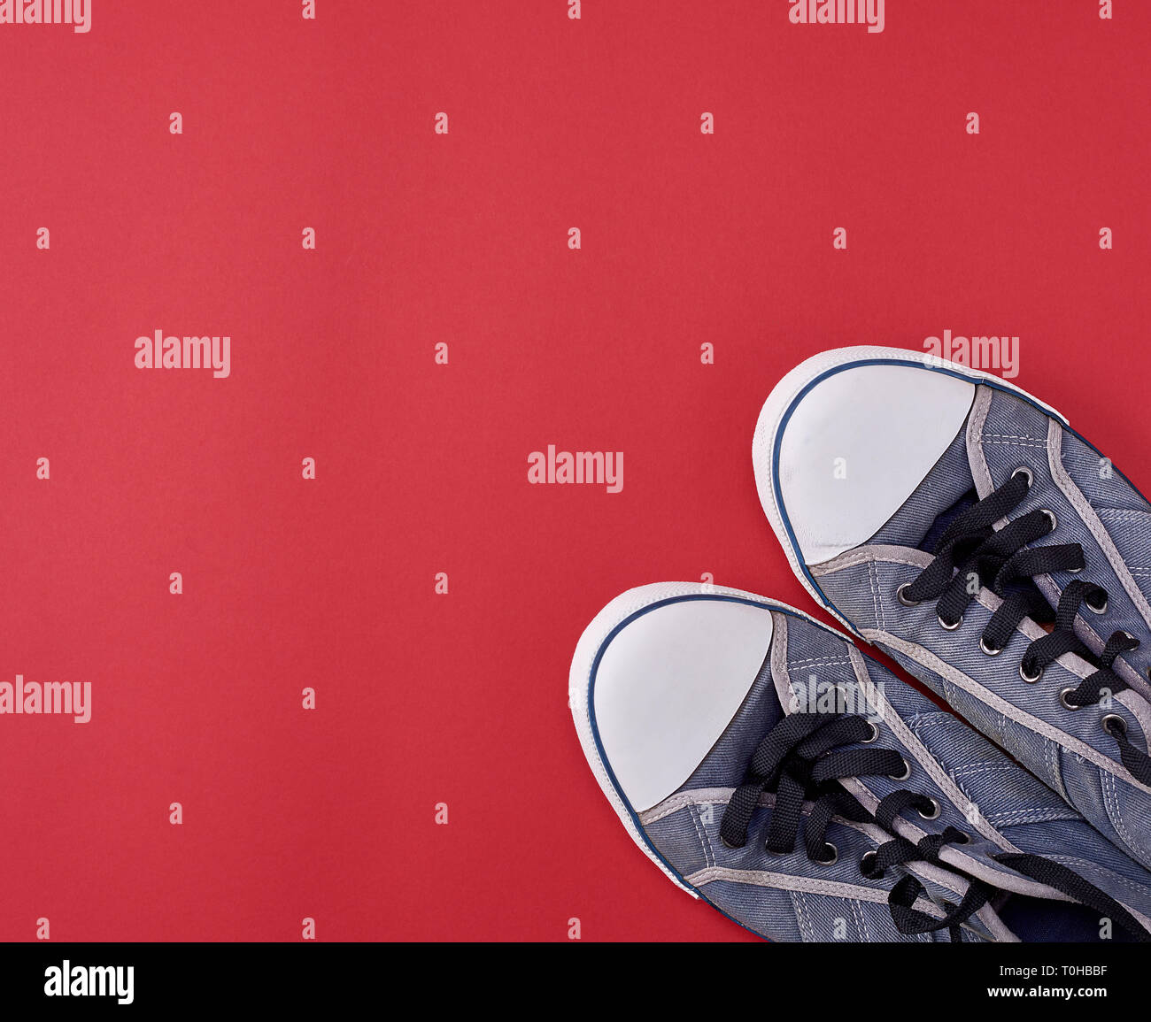 pair of black old textile sneakers on a red background, copy space ...
