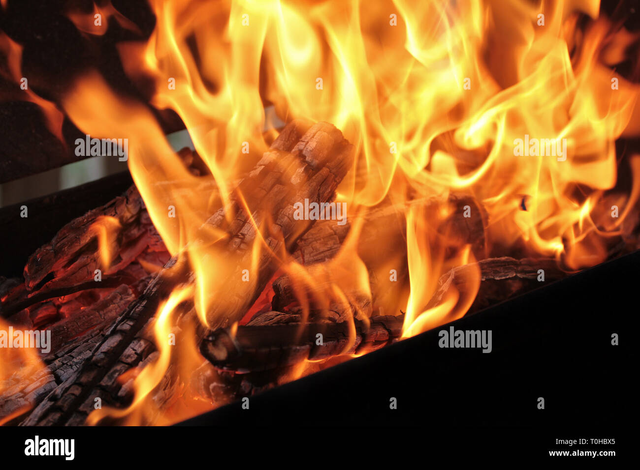 A shot of burning firewood in the fireplace. Closeup. Burning wood for a barbecue. Smoke and