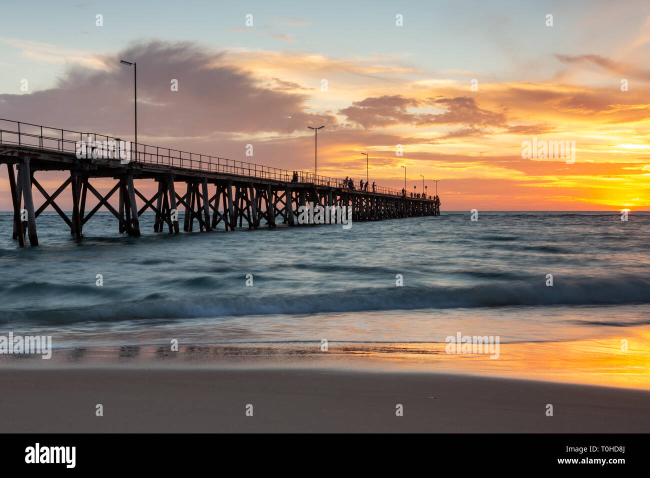 A beautiful sunset at Port Noarlunga with the jetty and motion blur on the water at Port Noarlunga South Australia Stock Photo