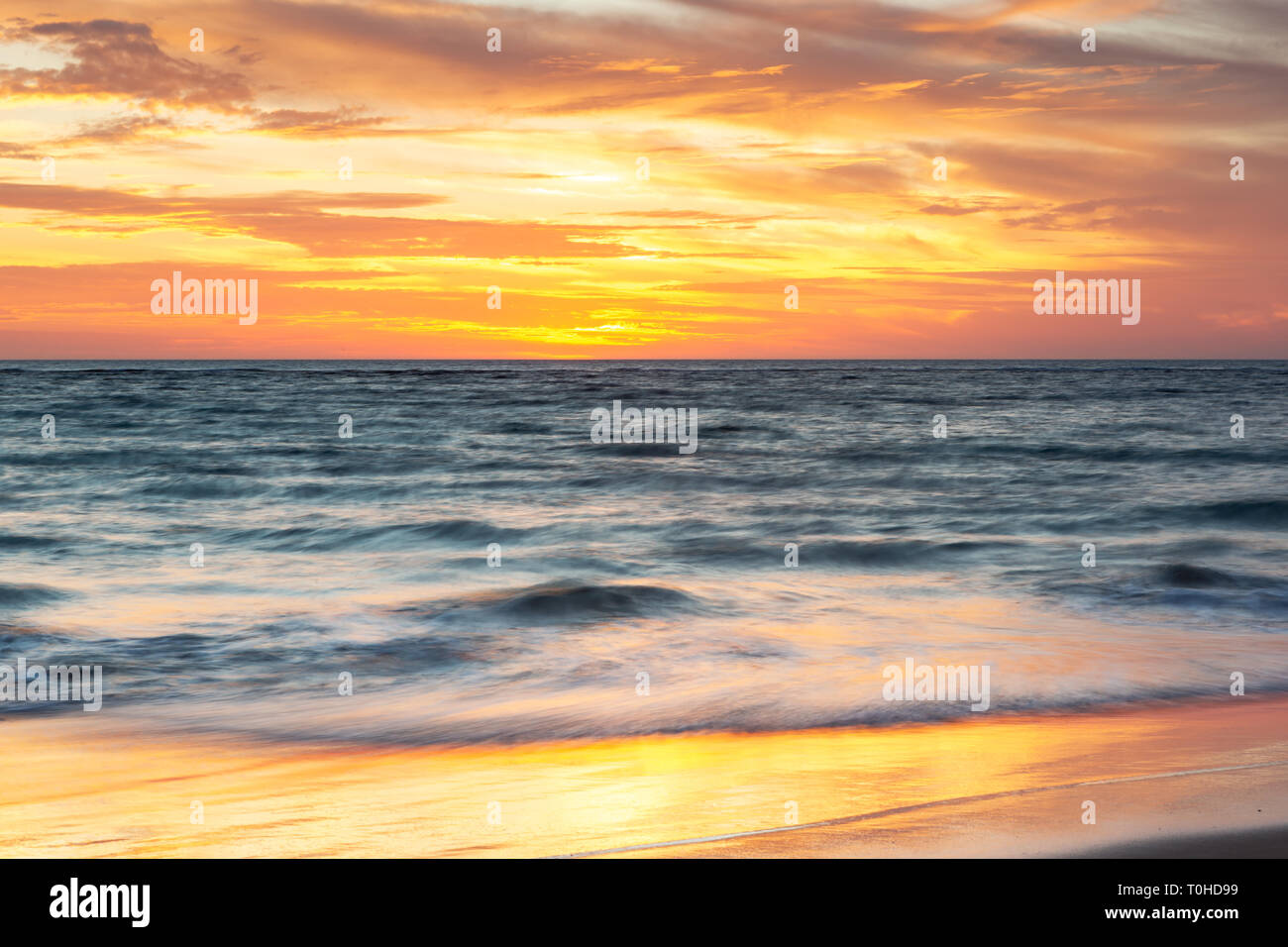 A beautiful sunset at Port Noarlunga with sunset reflections on the sand at Port Noarlunga South Australia Stock Photo