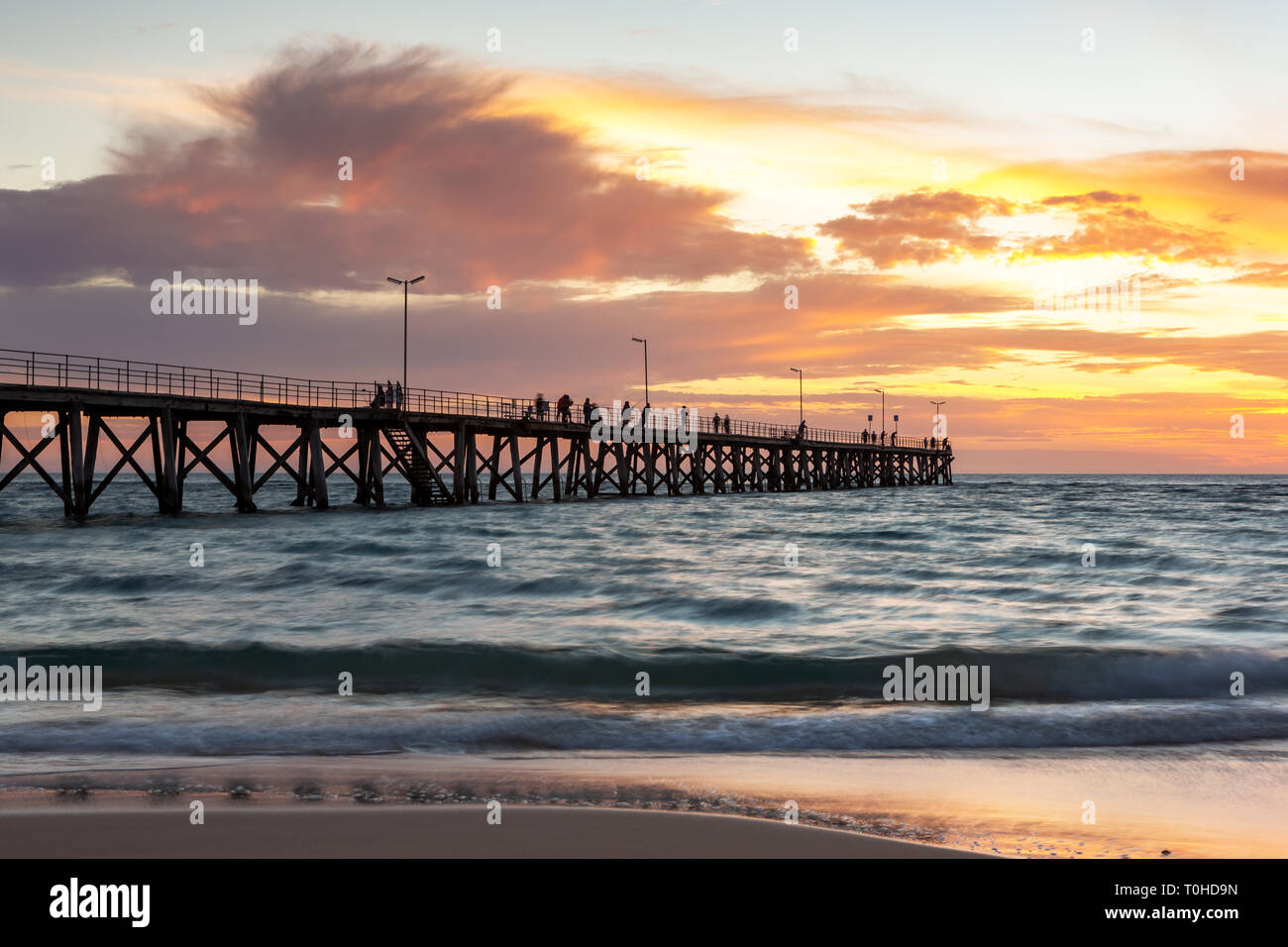 A beautiful sunset at Port Noarlunga with the jetty and motion blur on the water at Port Noarlunga South Australia Stock Photo