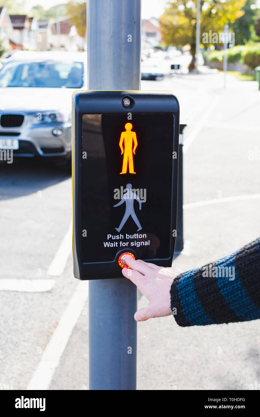 pushing a button of a signal traffic light at pedestrian crossing Stock Photo