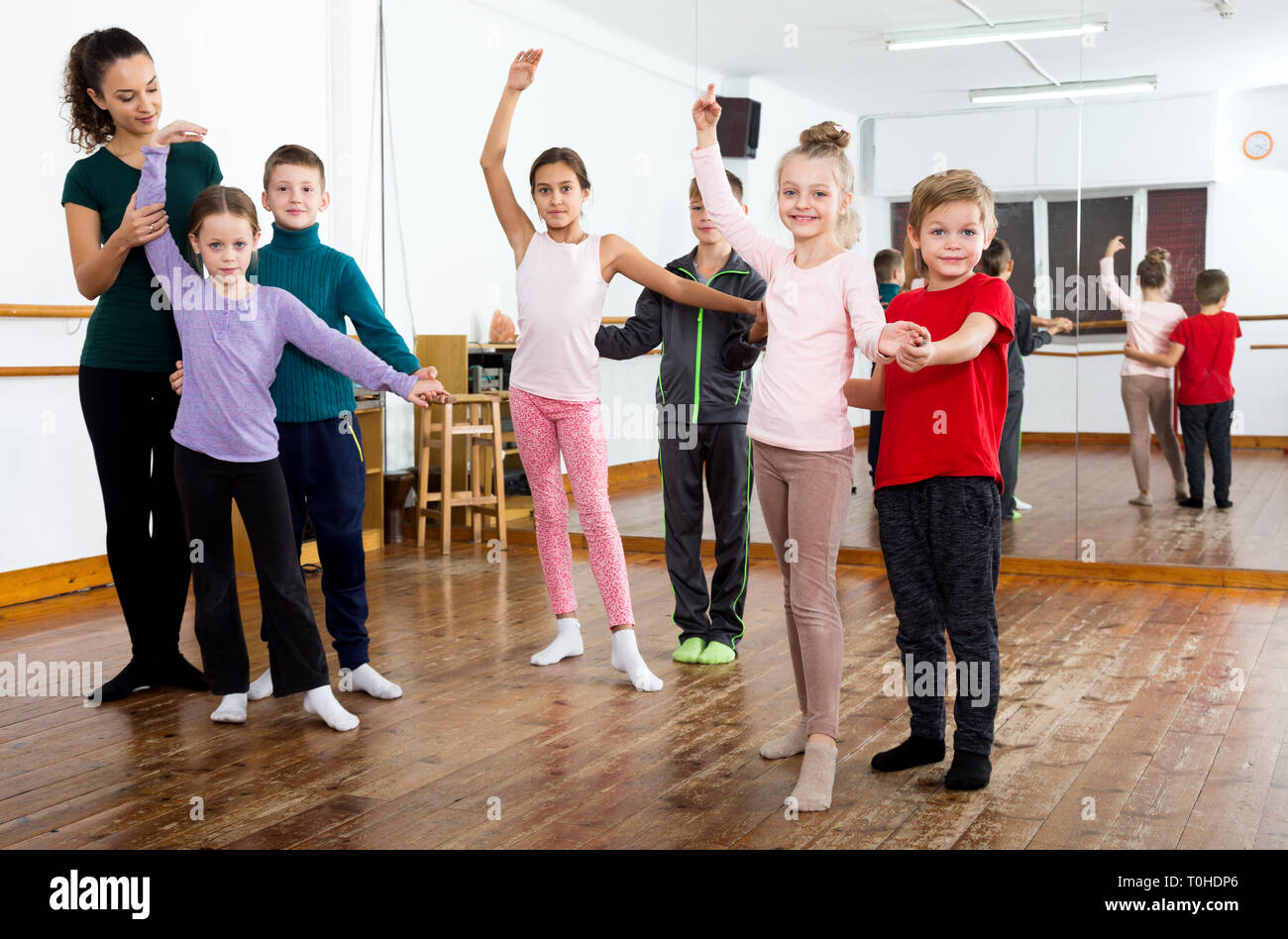 Cheerful little boys and beautiful girls having dancing class Stock