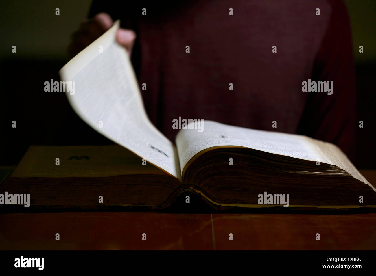 Man Flipping through the Pages of an old book Stock Photo