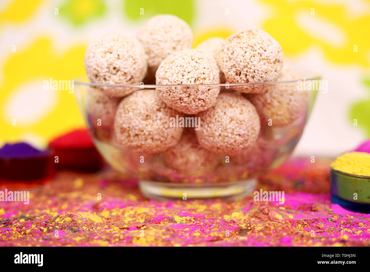 Picture of organic holi color with cholai ke ladoo in the bowl. Isolated on the colorful background. Stock Photo