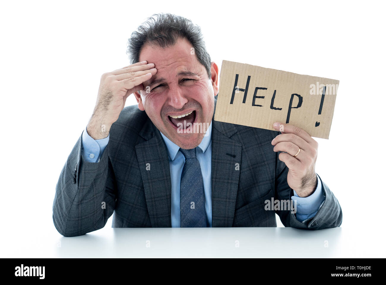 Stressed and desperate middle aged caucasian businessman holding a help sign looking frustrated, hopeless, in despair, upset and unhappy. In stress at Stock Photo