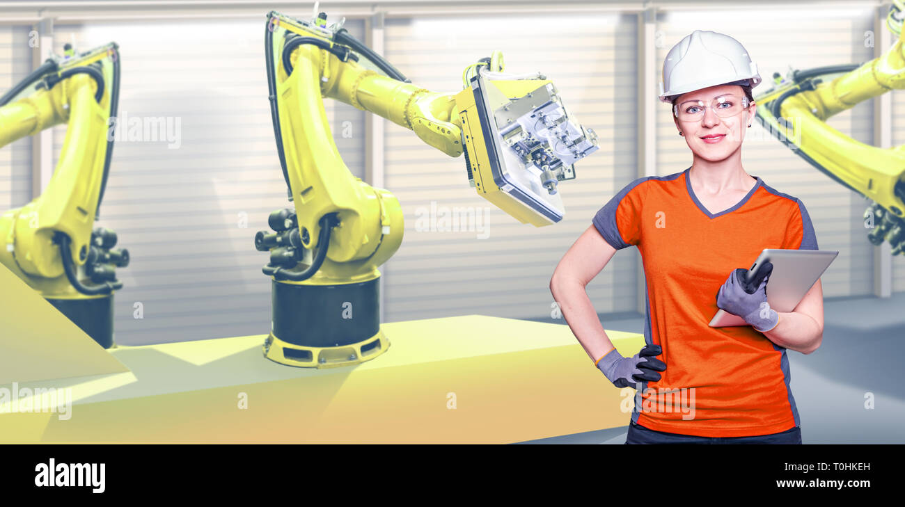A young female technician while machine constructing in a manufacturing plant Stock Photo