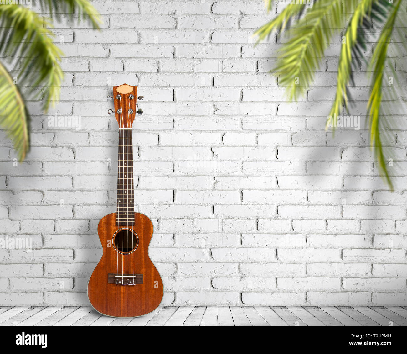 Ukulele guitar on a white wall background. Concept of travel and