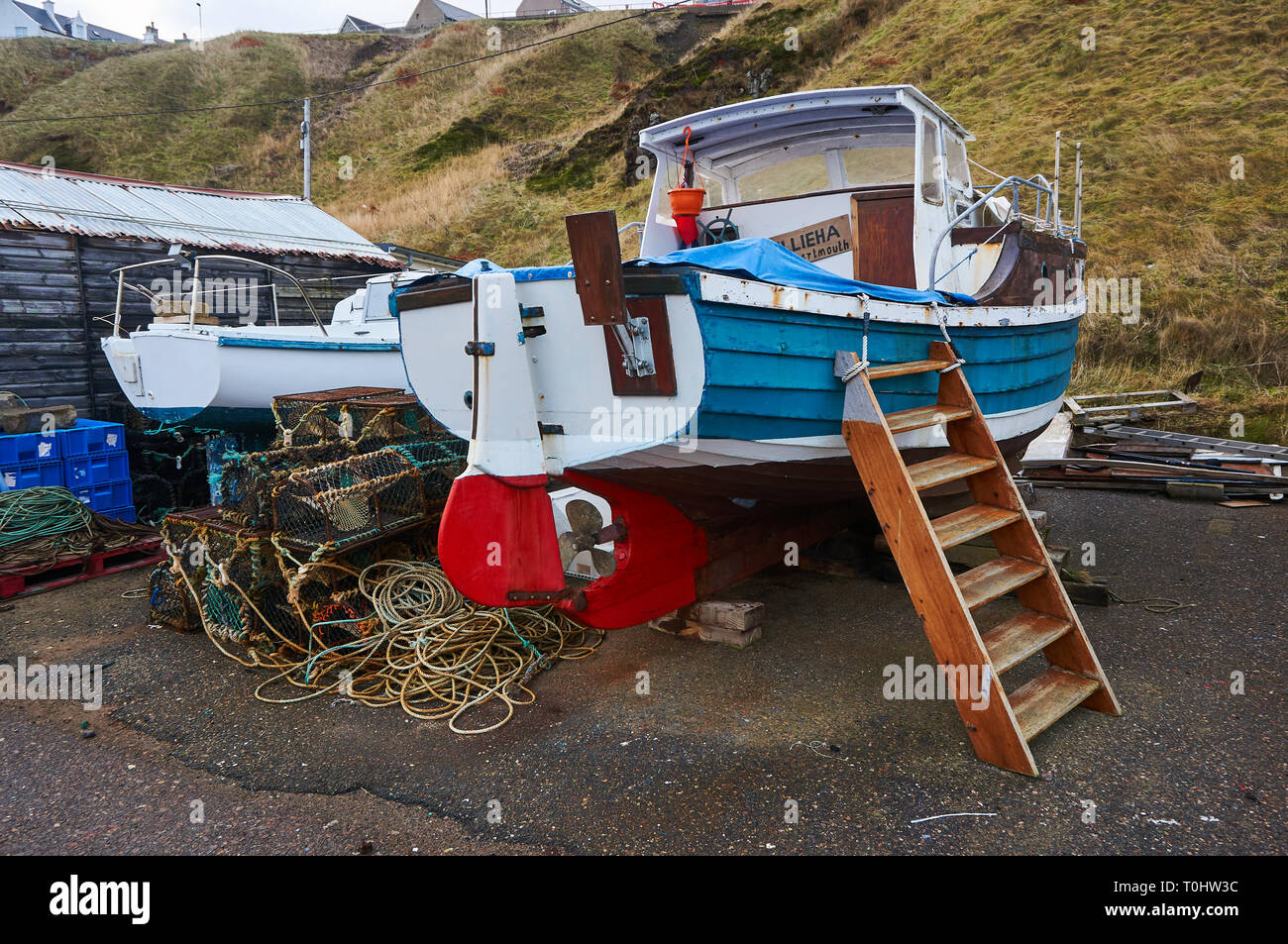 An old fishing boat and lobster / crab creel in the harbor of Portknockie, Scotland, UK. Stock Photo