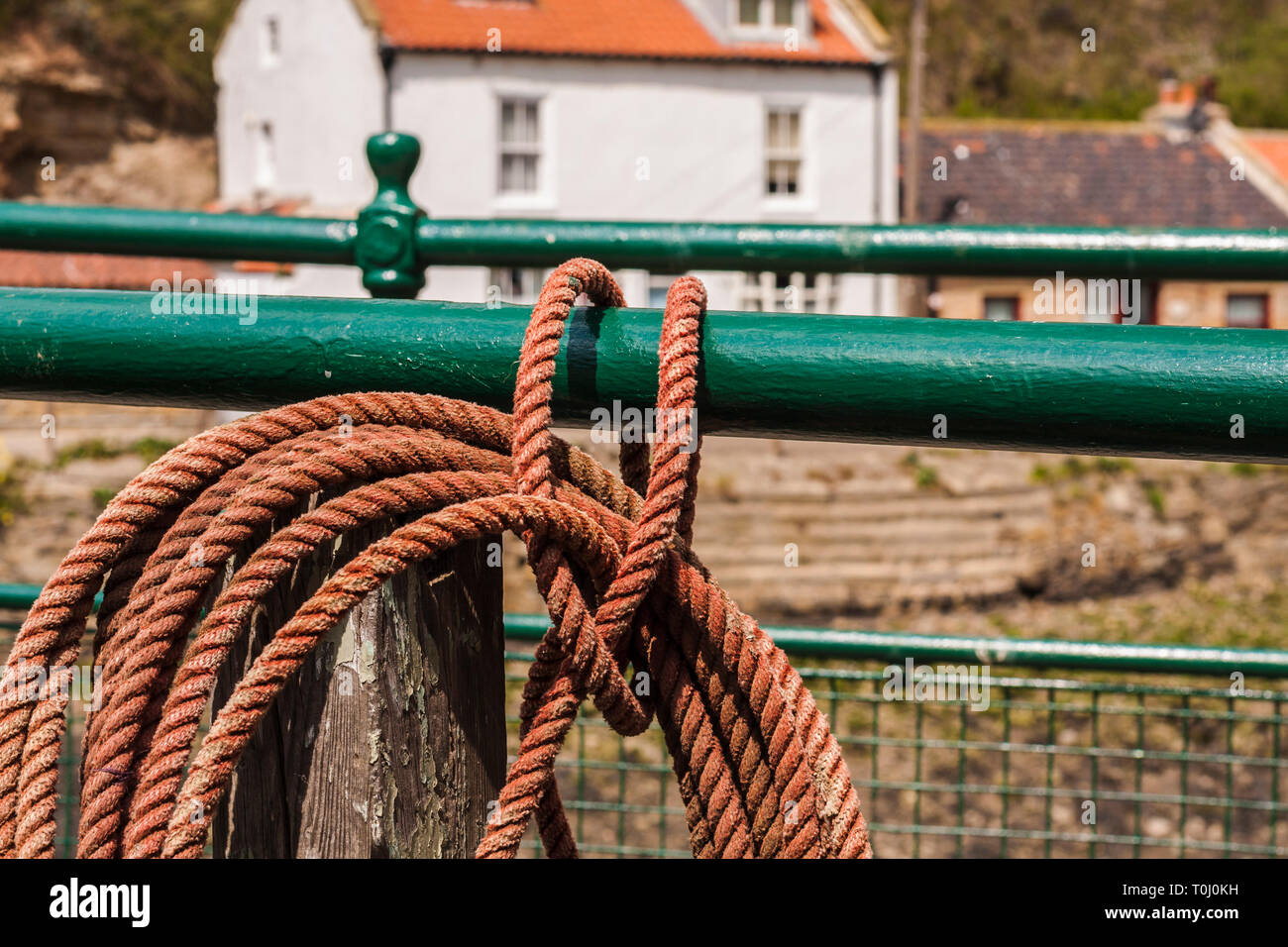 Orange corded rope wrapped round the railings on the footbridge at ...