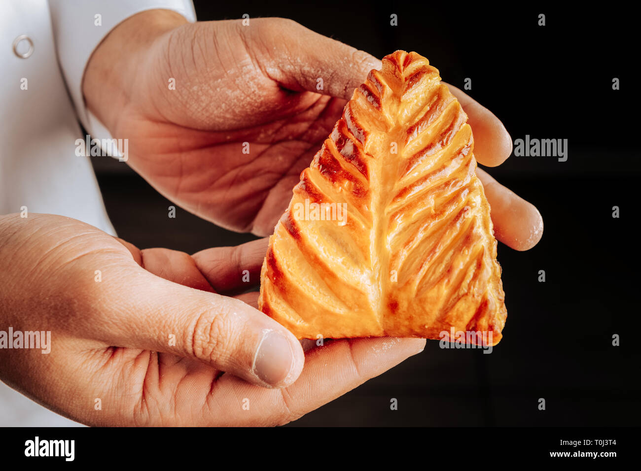 Baker holding nice little bun with cottage cheese inside Stock Photo