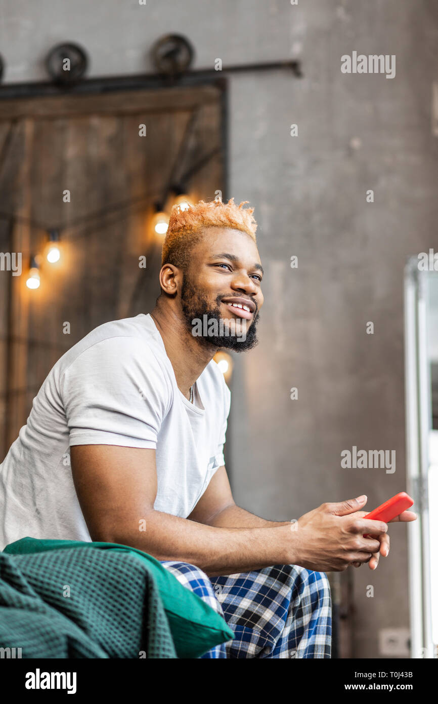 Nice good looking man sitting with his phone Stock Photo