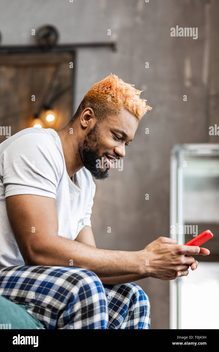 Delighted nice man looking at his smartphone screen Stock Photo