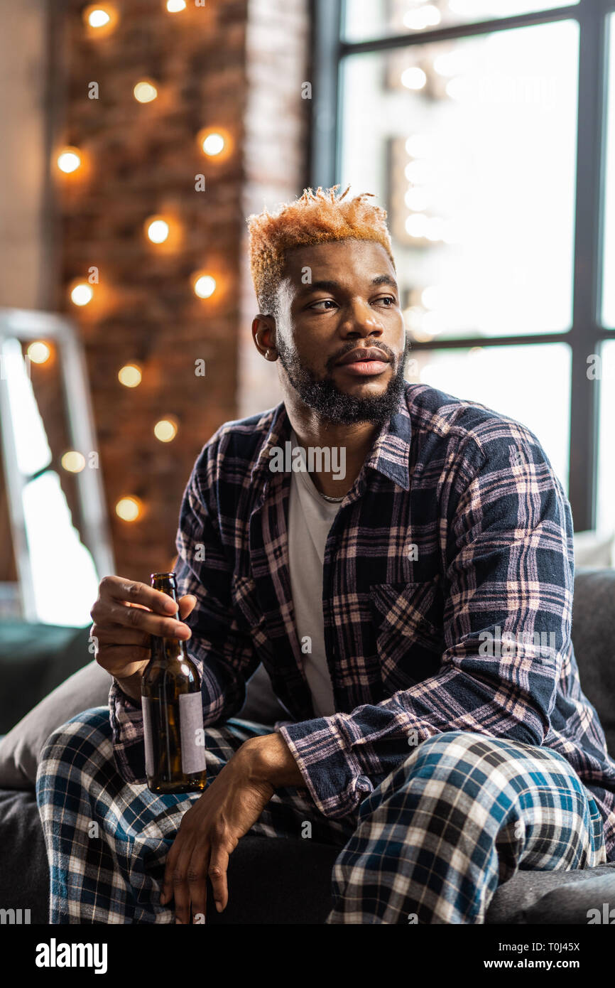 Pleasant young man being dressed in pyjamas Stock Photo