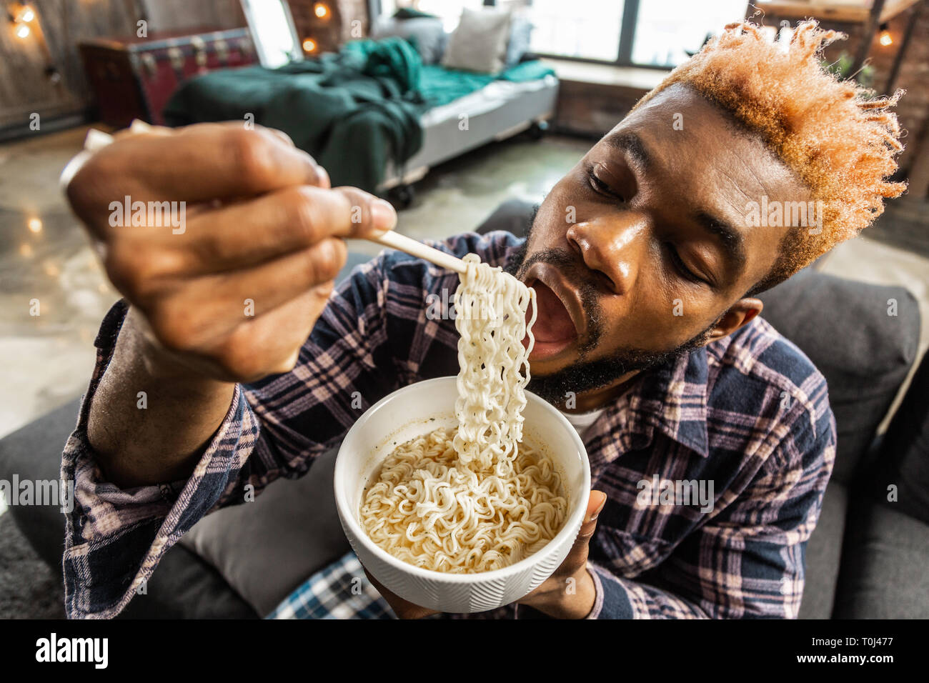 Good looking young man being extremely hungry Stock Photo