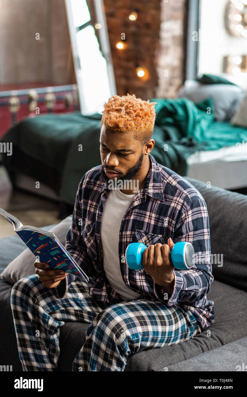 Serious young man being involved in reading Stock Photo