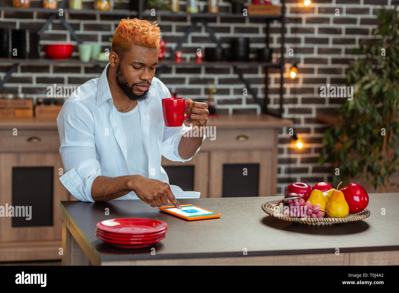 Nice thoughtful young man using his tablet Stock Photo