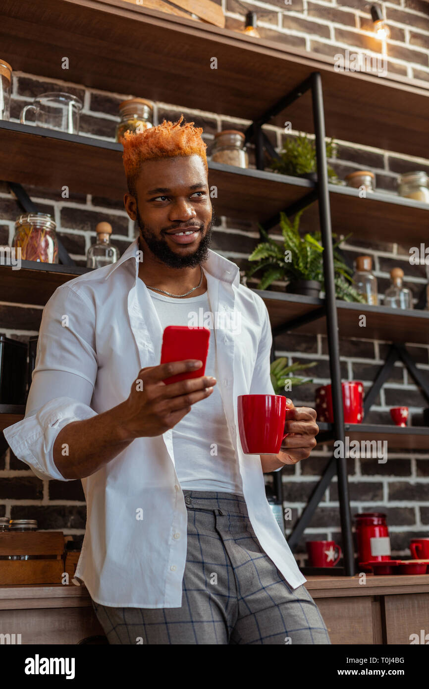Pleasant good looking man using his smartphone Stock Photo