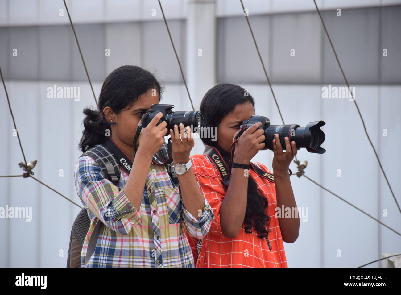 Two young female(women) photographers taking photos(pictures) Stock Photo