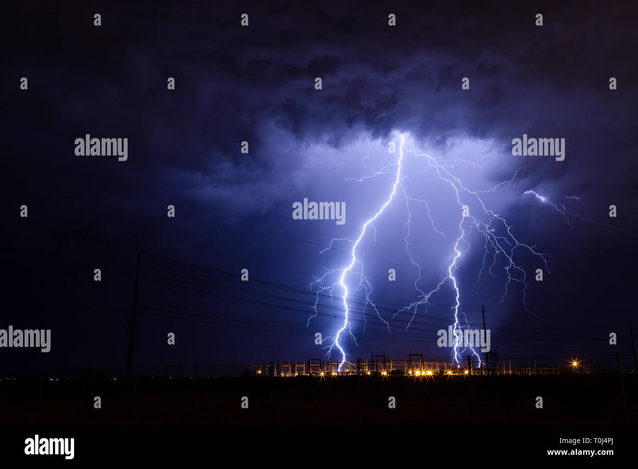 Lightning storm with bolts striking an electrical substation near