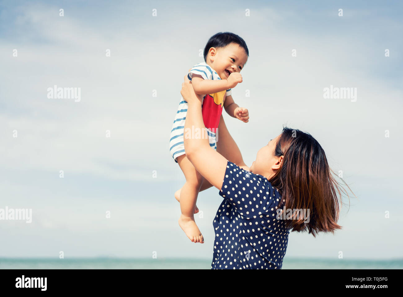 Happy asian family playing at the beach hi-res stock photography and ...