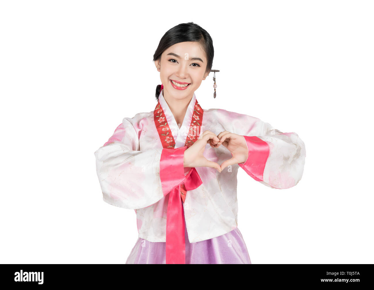 Asian woman in Korean traditional dress making heart shape with arms on white background isolated with clipping path Stock Photo