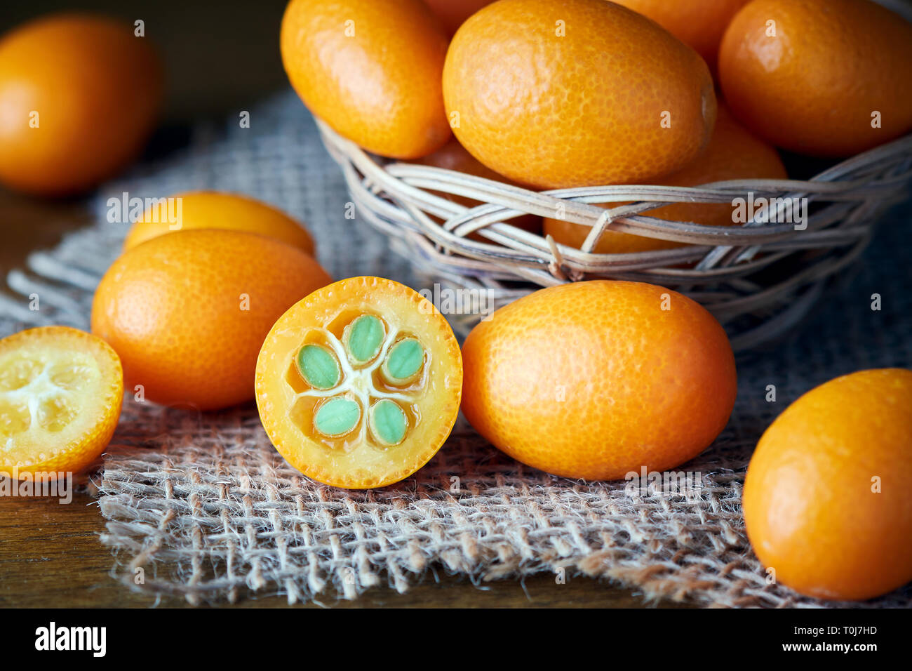 Kumquats or cumquats (Citrus japonica) on wooden background Stock Photo