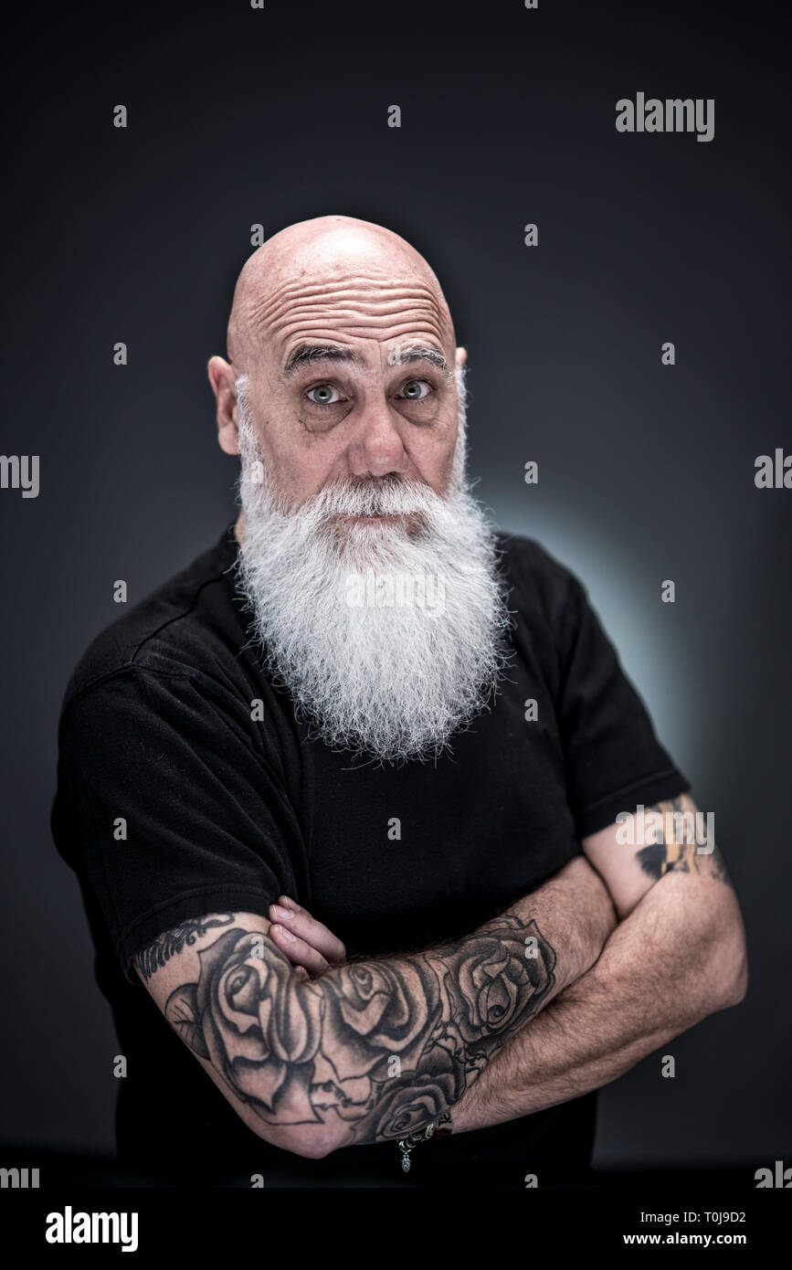 Studio Portrait Of A Bald Man With Tattooed Arms And White Beard Stock Photo Alamy