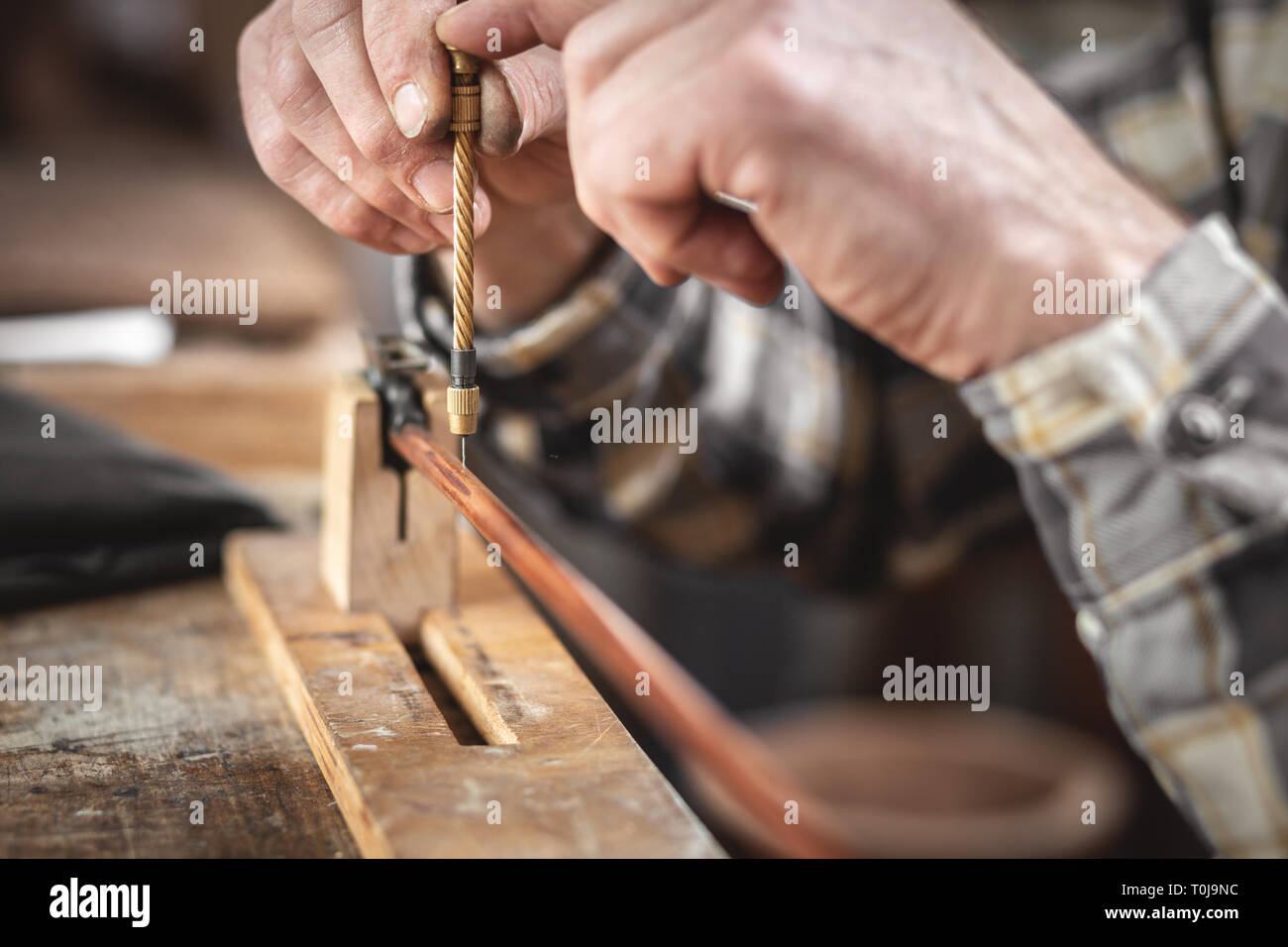 Close up of hands using a miniature drill Stock Photo
