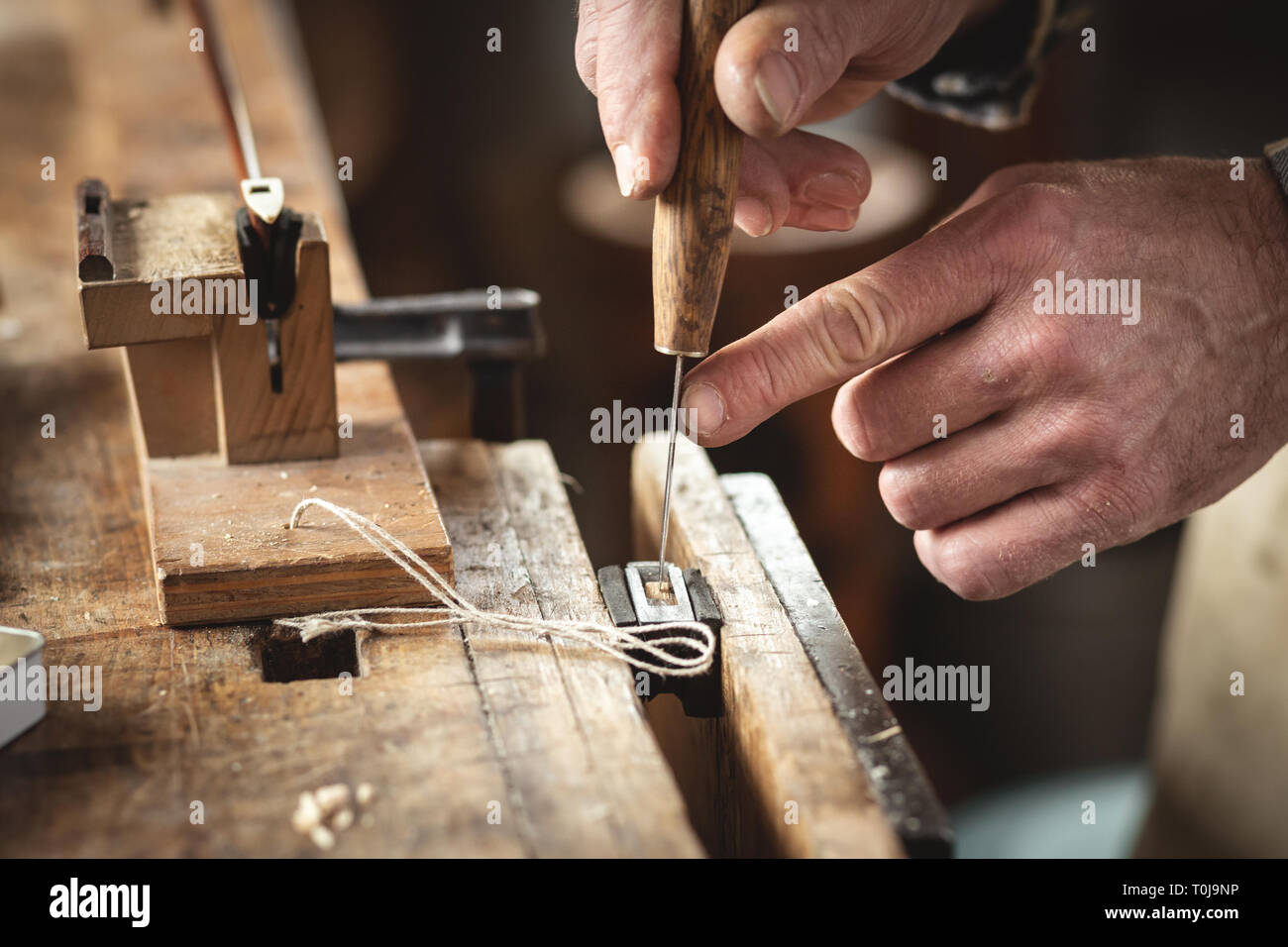 Inserting a wedge into a violin frog Stock Photo