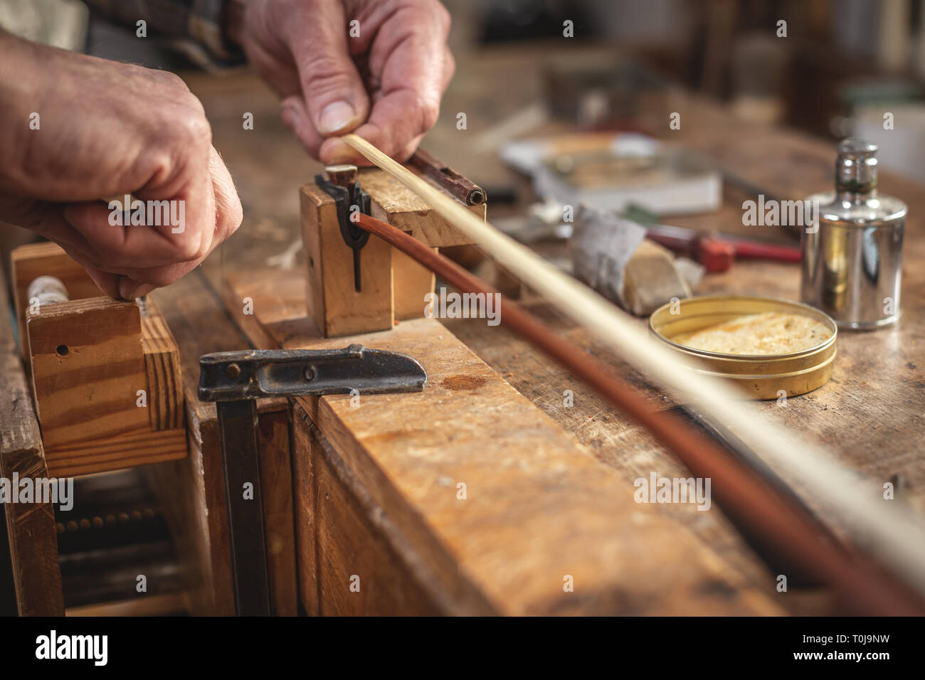 Violin maker working on a violin bow Stock Photo
