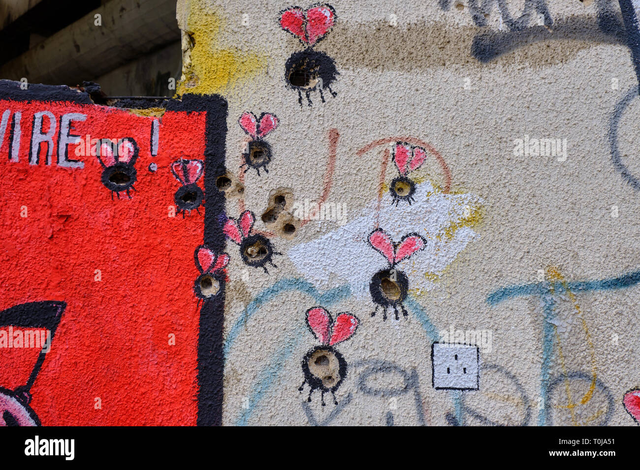 Wall art in Mostar, where the painter used bullet and shrapnel holes as part of design.  Bullet holes used as body of bugs Stock Photo