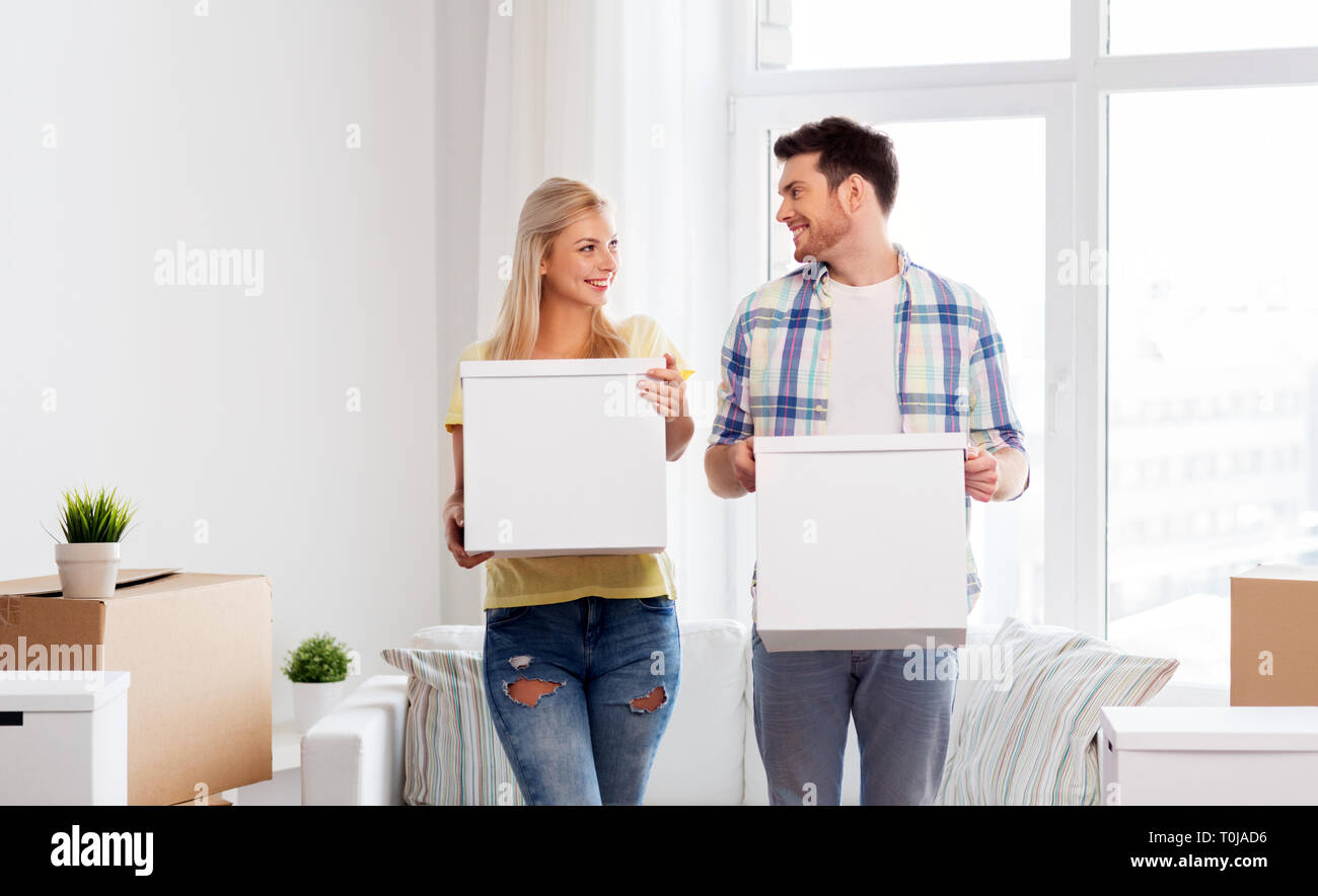 happy couple with boxes moving to new home Stock Photo - Alamy