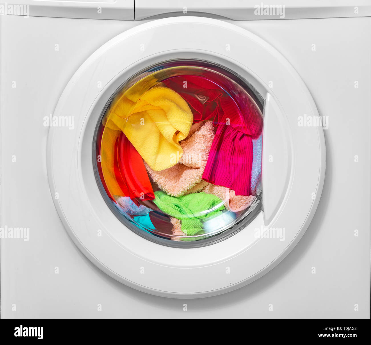 Washing machine with laundry loaded for washing. Stock Photo