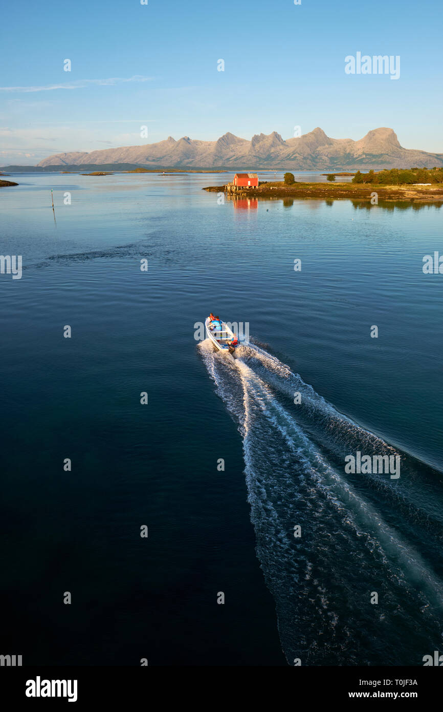 Exploring the many islands and coastline summer seascape of Heroy and Alsta and the distant Seven Sisters mountain range in Helgeland Nordland Norway Stock Photo