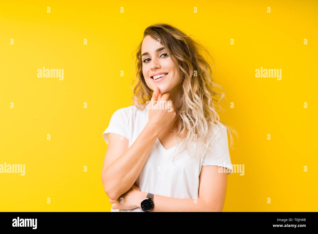 Young beautiful blonde woman over yellow background looking confident ...
