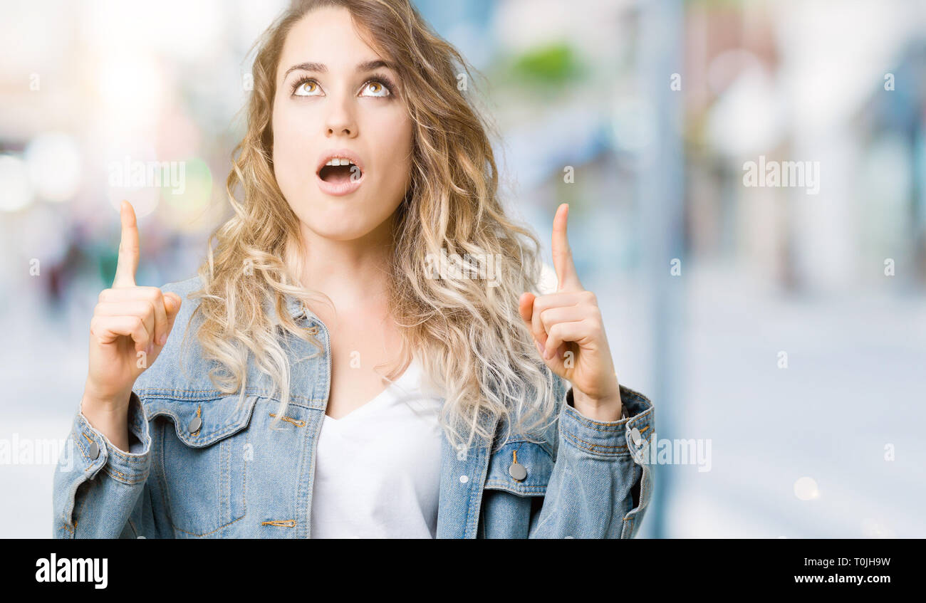 Beautiful young blonde woman wearing denim jacket over isolated ...