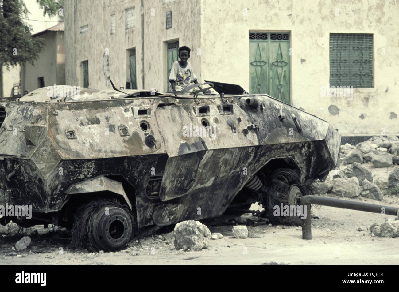 25th October 1993 A young boy plays on top of a burnt-out Malaysian Condor APC that was attacked by Somalis on the 3rd of October as it was trying to rescue 70 US Rangers during the 'Black Hawk down' incident in the Bakara Market area of Mogadishu, Somalia. Stock Photo