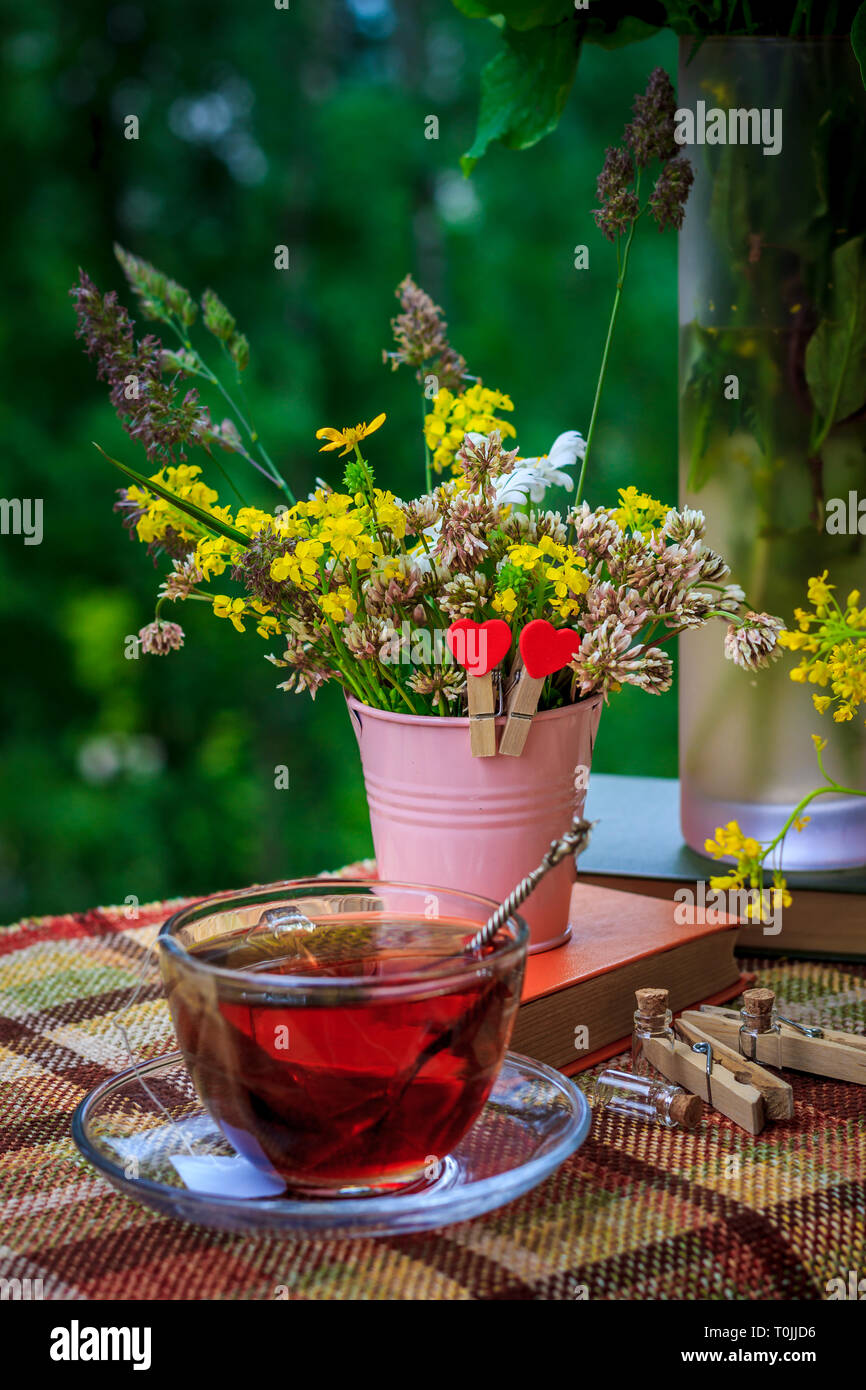 Summer tea with a book on the terrace. Summer tea with a bouquet of ...