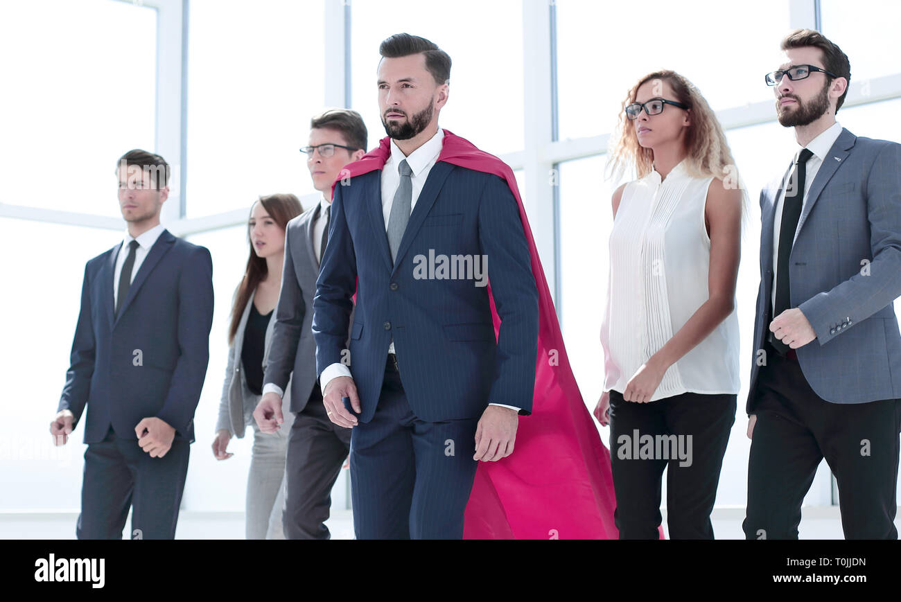 businessman in Superman cloak and business team standing in office lobby Stock Photo