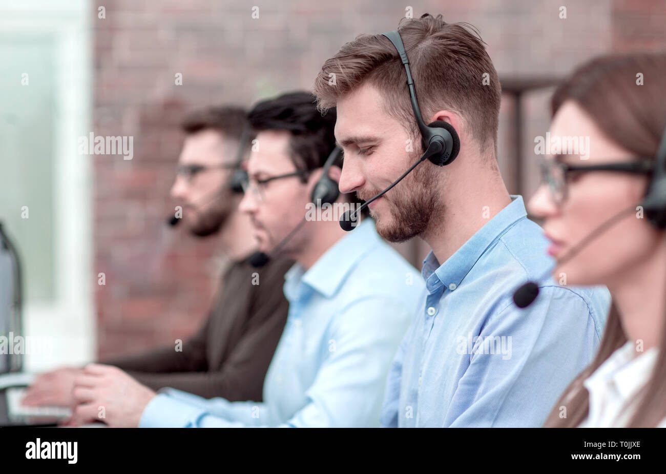 side view.the call center operator and her colleagues work in the office. Stock Photo